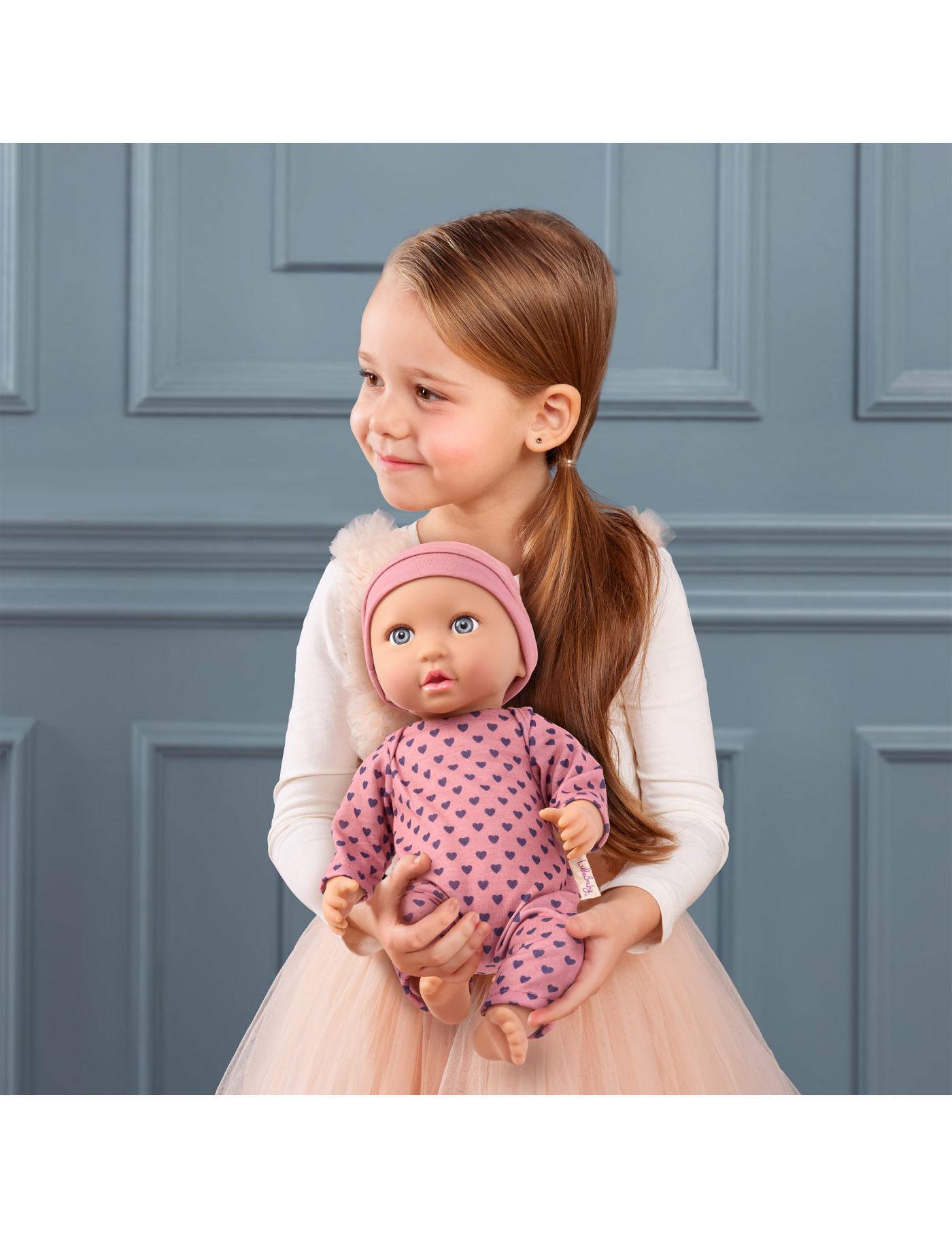 Lalka NIEMOWLĘ ze smoczkiem, w pidżamce w serduszka i czapeczce LullaBaby